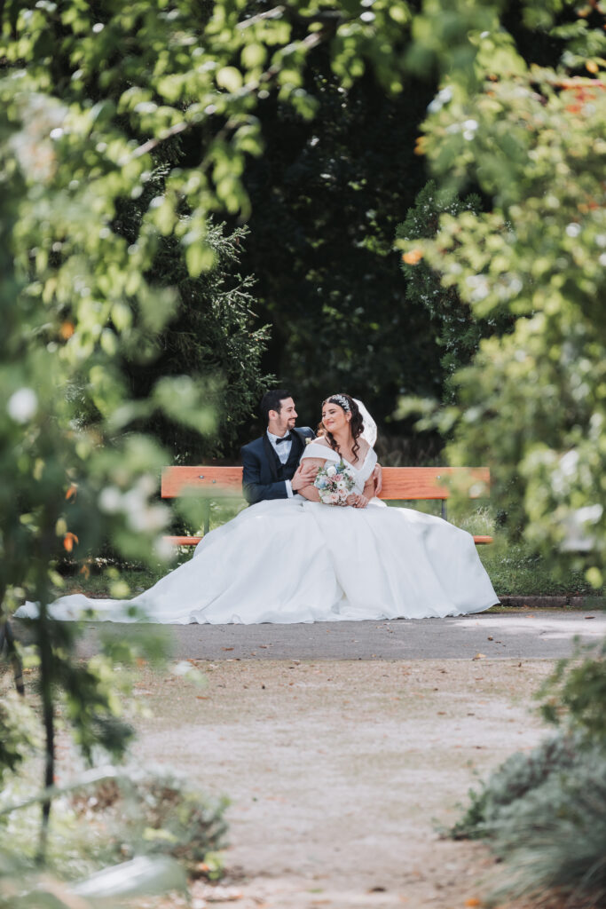 Un couple de mariés assis sur un banc du jardin botanique à Metz