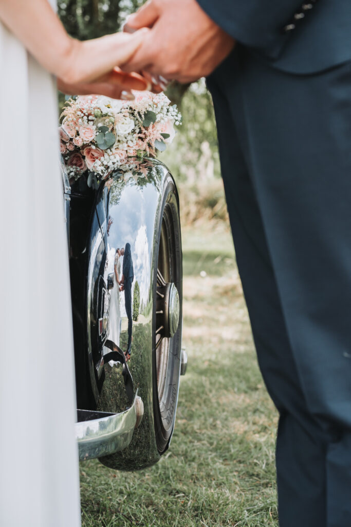 Le reflet des mariés dans une voiture ancienne au bord d'un étang de Moselle